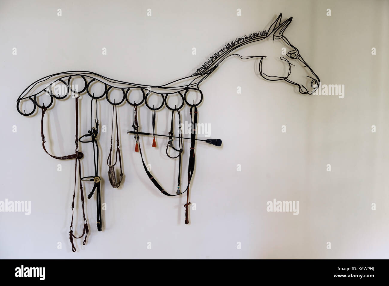 Artificial Horse shape decoration interior made by bridle attached on stable white wall by front view Stock Photo