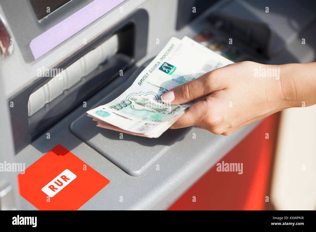 Russian rubles cash. Repayment on credit. Woman hand withdrawing money from outdoor bank ATM Stock Photo