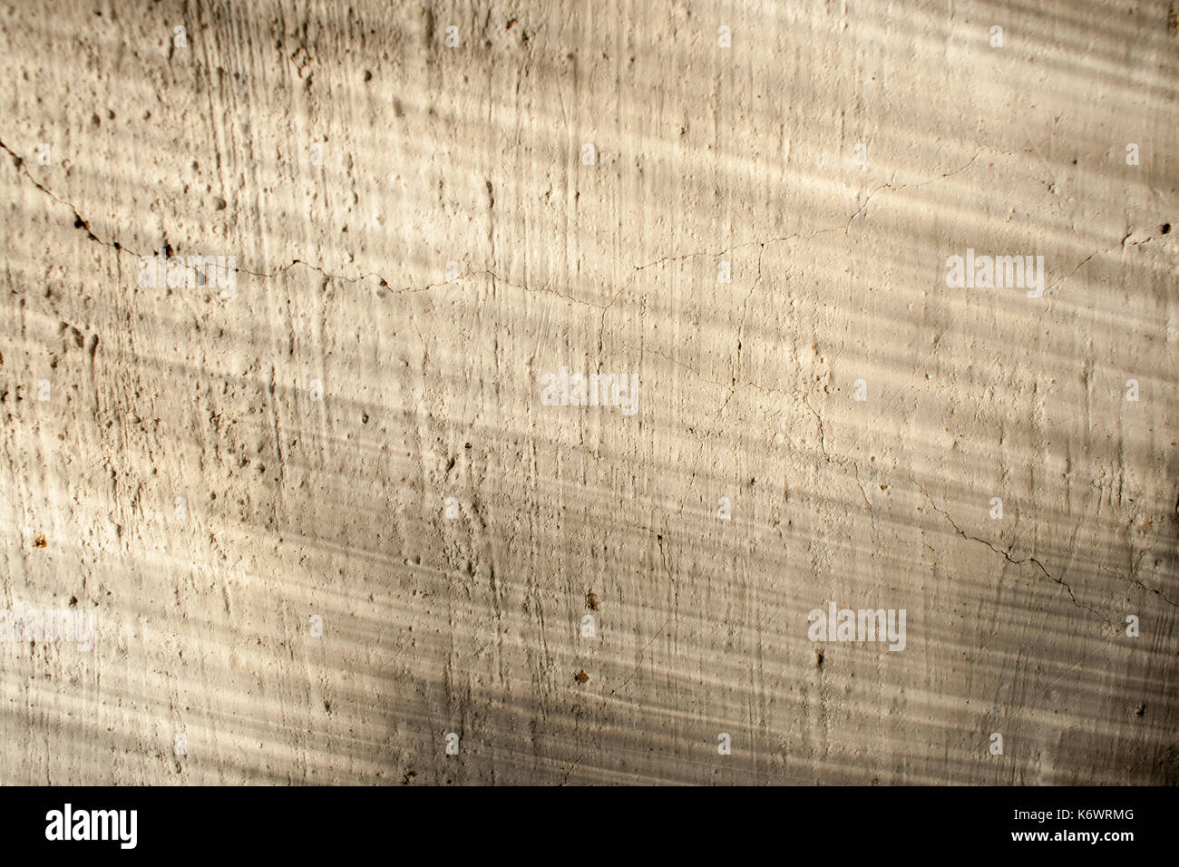Retro background. Old plastered flat surface with cracks and streaks of light and shadow on her. Stock Photo
