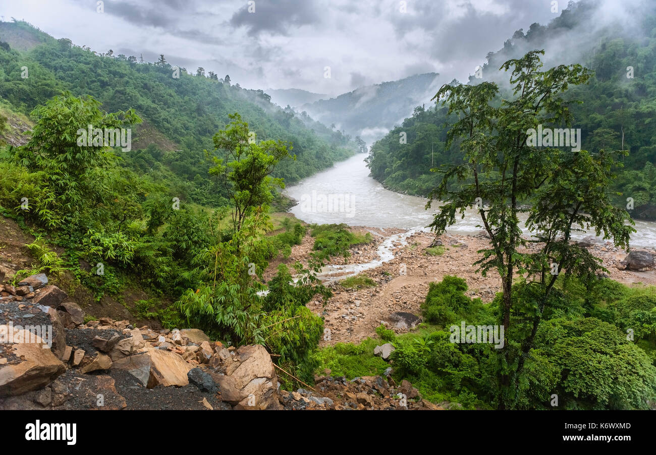 The Kameng river flanked by forested slopes and boulders on a misty monsoon day as viewed from National Highway 13 , Bomdila, Arunachal Pradesh, India. Stock Photo