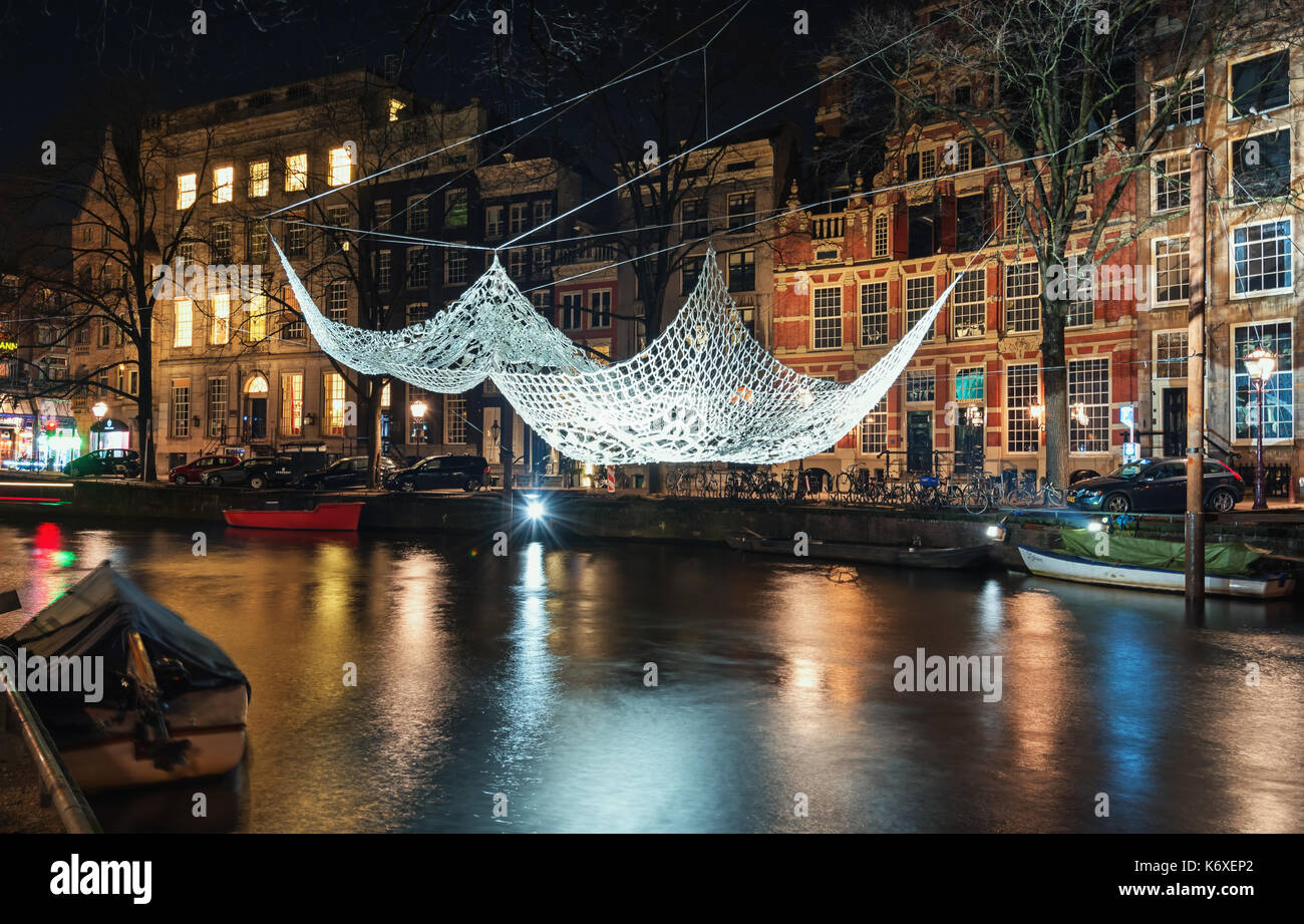 Amsterdam, Netherlands – January 5, 2017: Crochet and illuminated giant bedspread float above a canal during the Festival of Light in Amsterdam Stock Photo