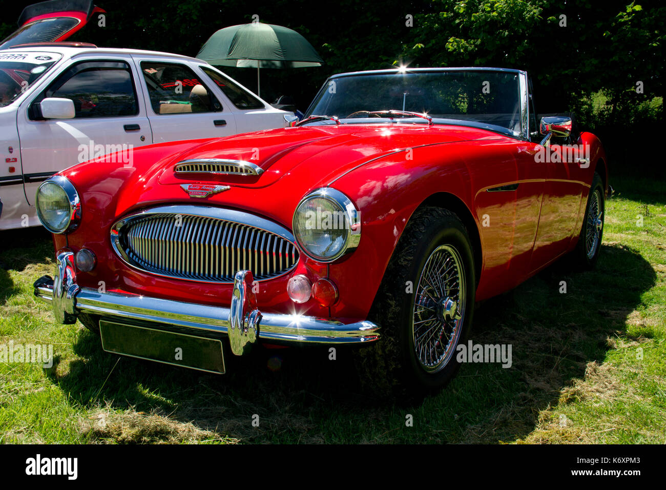 Front view of a bright red Austin Healey sports car on display at a classic car show in Wales UK Stock Photo