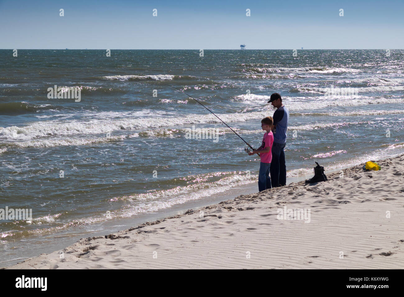 Father and son surf fishing in the Gulf of Mexico at Golf Shores, Alabama the day after hurricane Irma hit Florida. Stock Photo