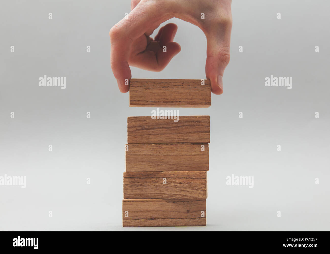 Male hand stacking wooden blocks. Business development and growth ...