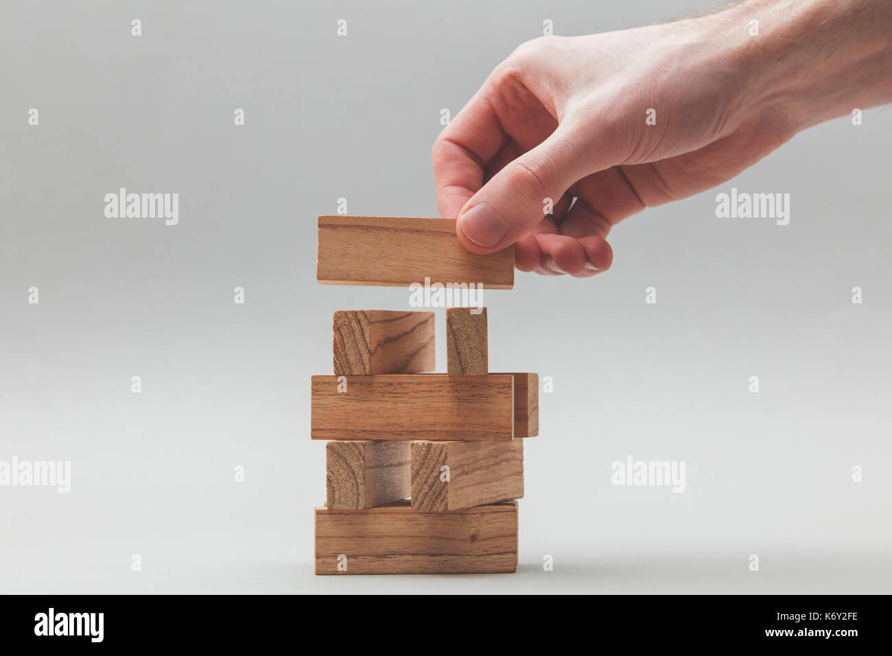 Male hand stacking wooden blocks. Business development and growth ...