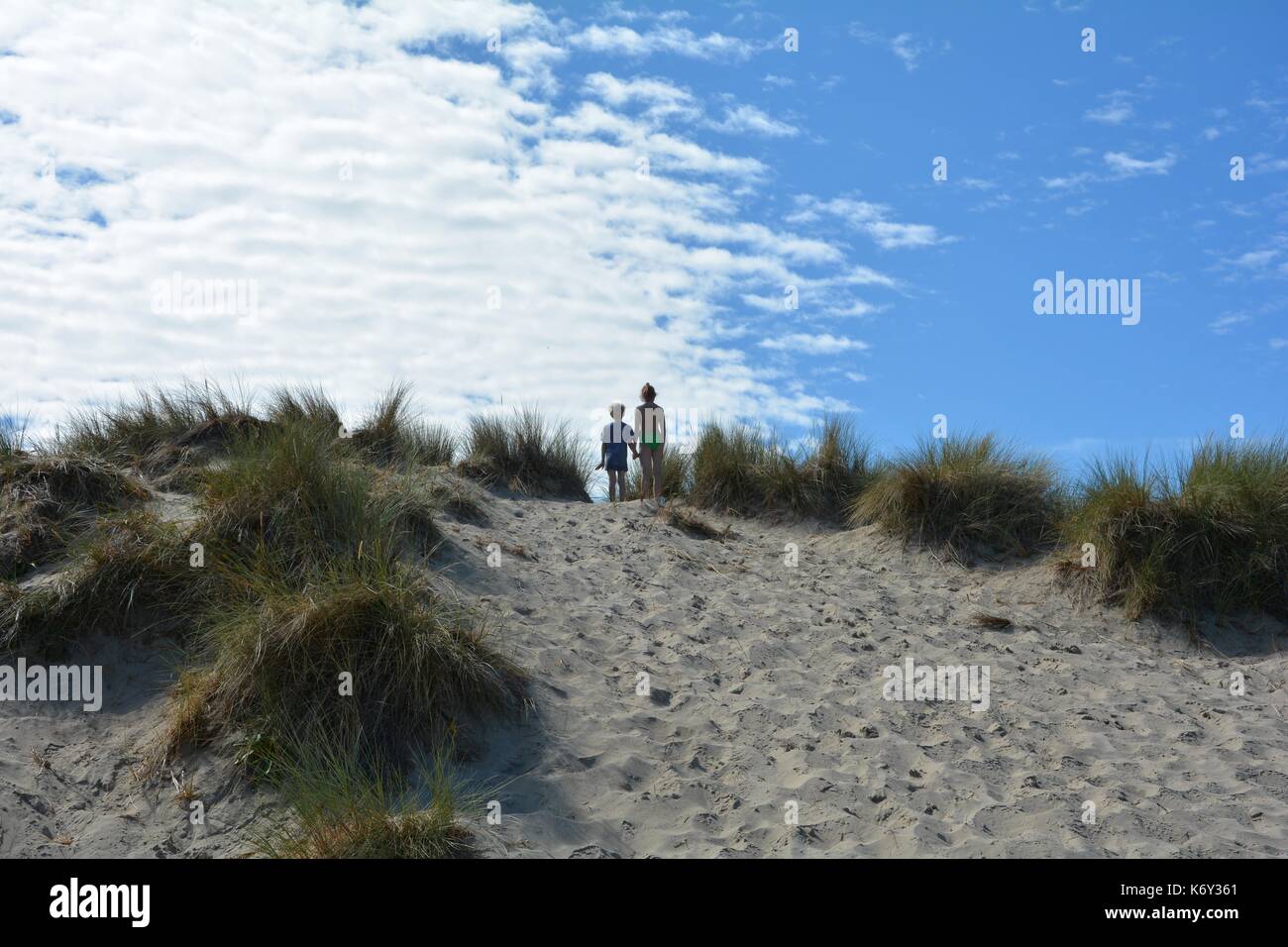 Two children on top on a sandy dune, in the middle of the beach oat on the North Sea coast Stock Photo