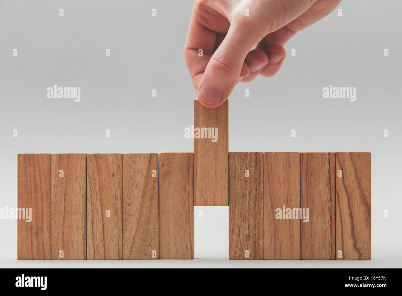 Male hand stacking wooden blocks in a line. Business development and ...