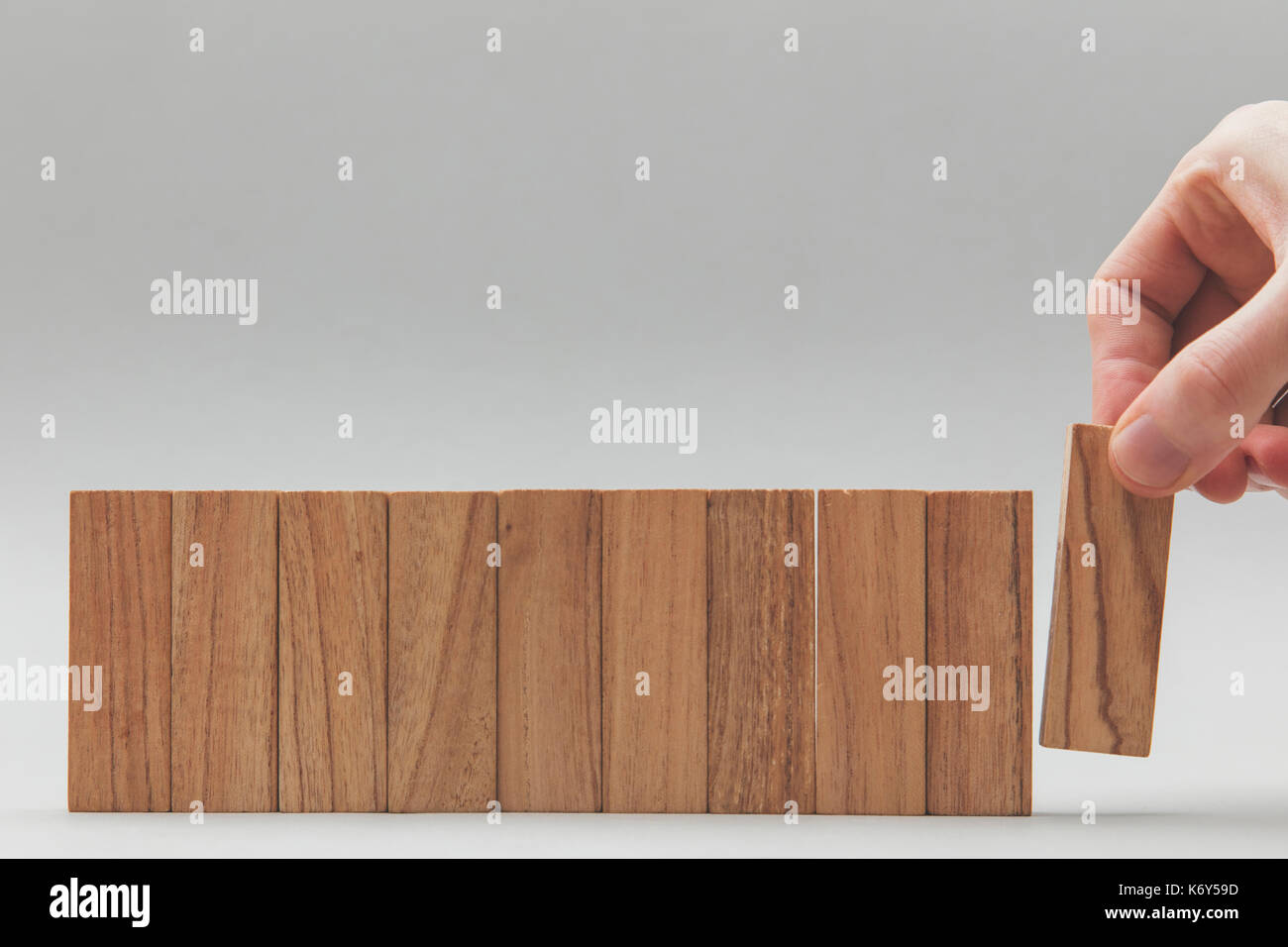 Male hand stacking wooden blocks in a line. Business development and ...