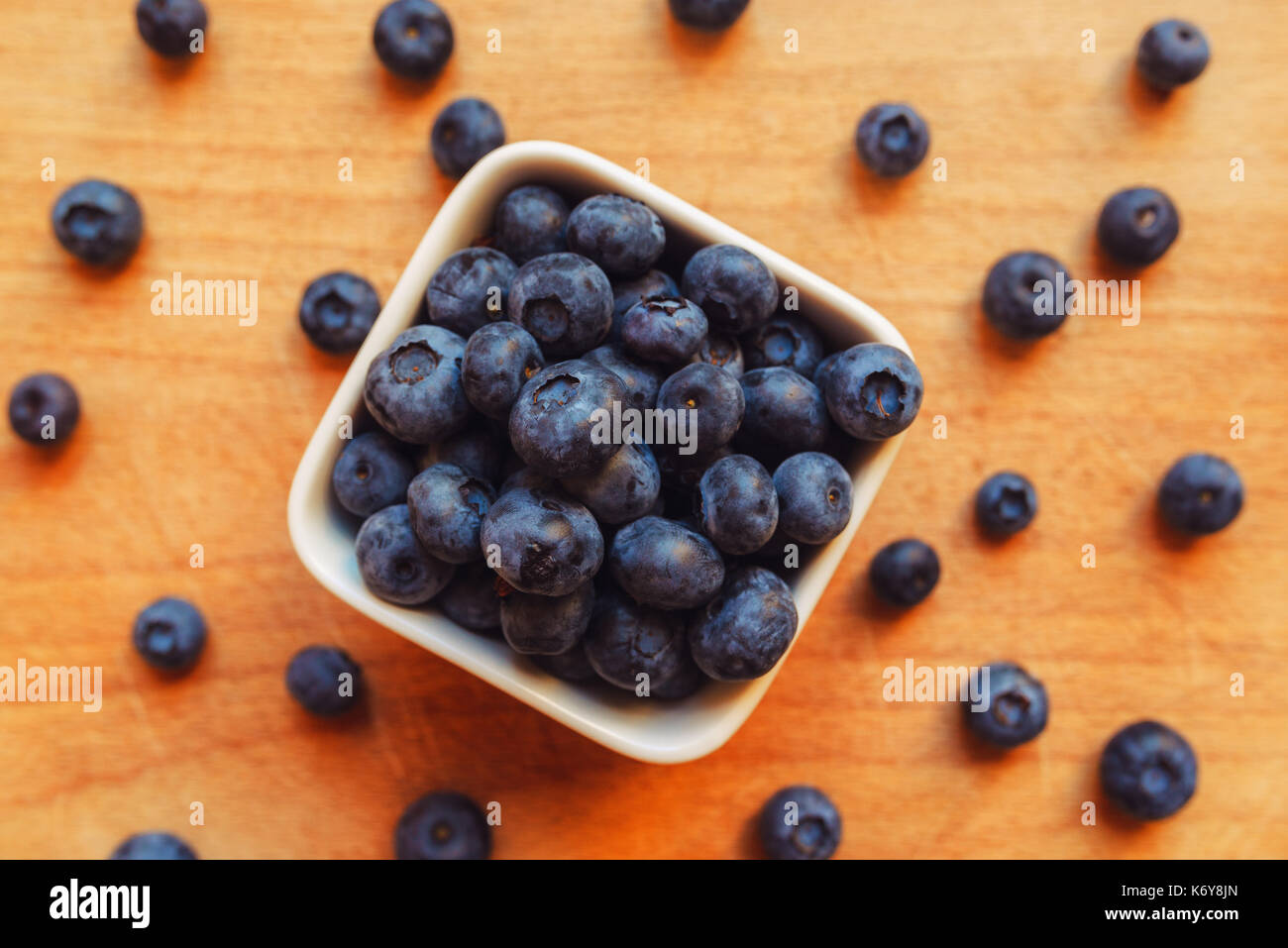 Blueberries in white ceramic bowl on table Stock Photo