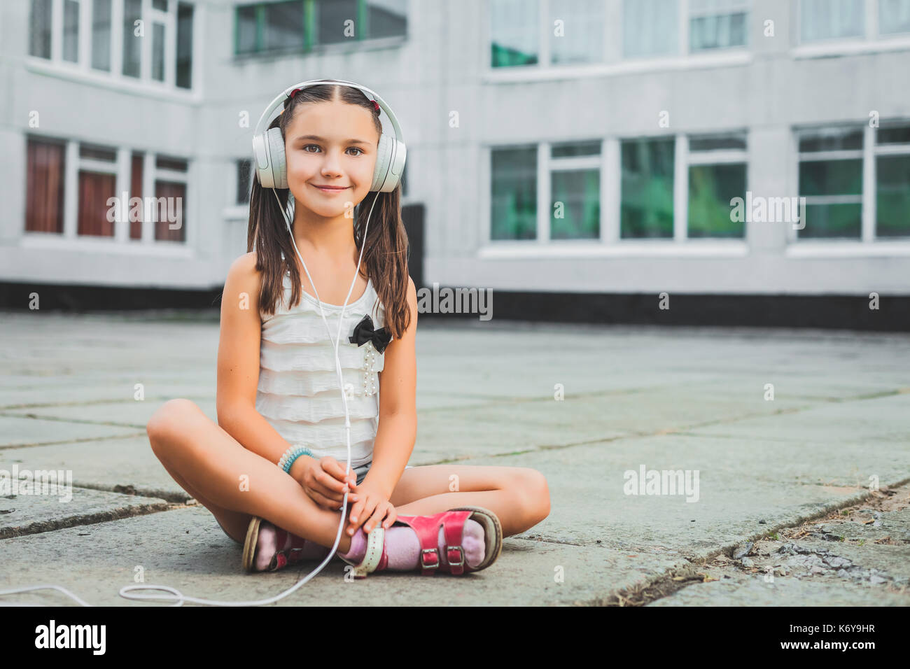 Pretty girl sitting and listening music with headphones Stock Photo - Alamy