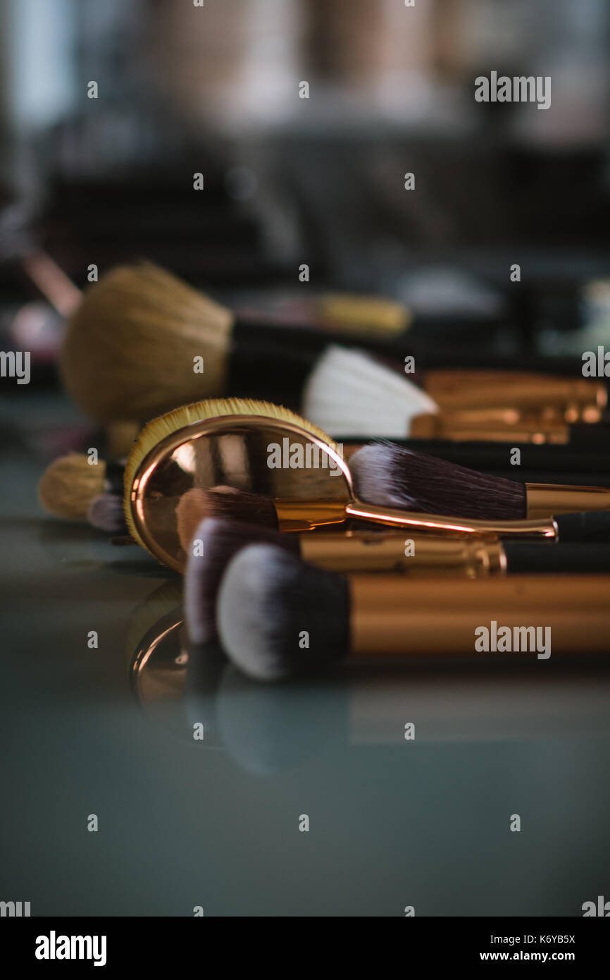 Set of professional makeup brushes on glass table with shallow depth of field Stock Photo