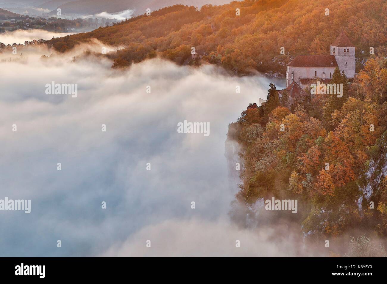 France, Lot, valley of the river Lot, Natural regional park Causses du Quercy, Saint Cirq Lapopie, listed as The most beautiful villages in France, Church of St Cirq emerging from a sea of mist in the valley Stock Photo