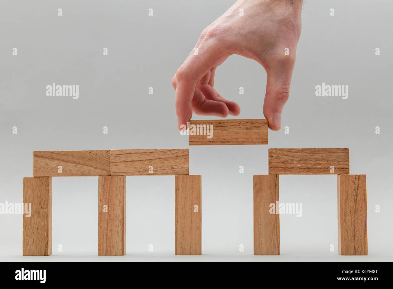 Male hand stacking wooden blocks. Business development and growth ...