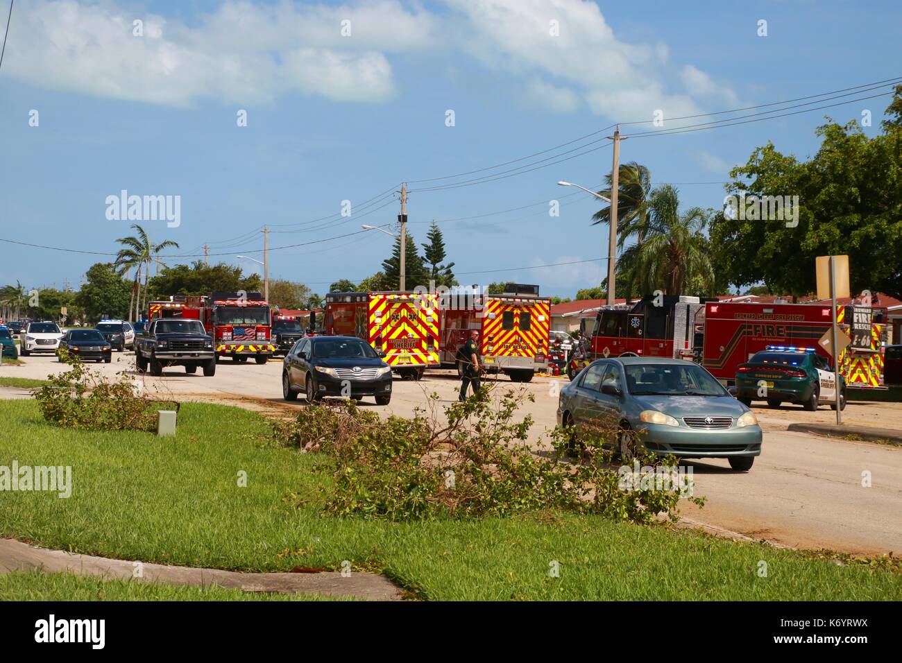 An Officer Standing in Front of Fire Trucks Diverts Traffic Around Auto Accident after Hurricane Irma Stock Photo