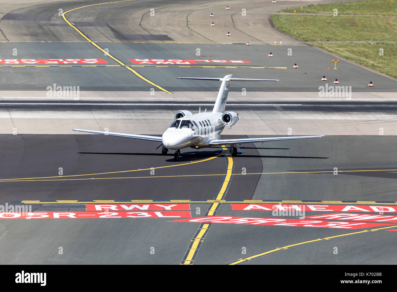 DŸsseldorf International Airport, Germany, marks on the taxiway, signpost, private jet plane Stock Photo