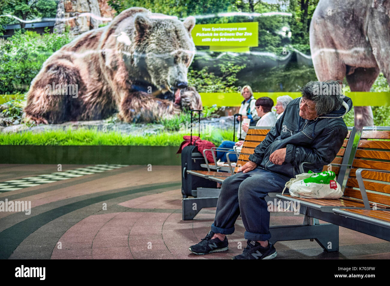 Germany An homeless drunk sitting on a bench of an hall of the Zoologischer Garten metro station, Berlin Stock Photo