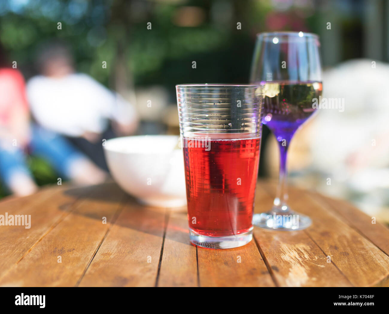 Summer beverages including fruit juice, wine and crisps on a wooden