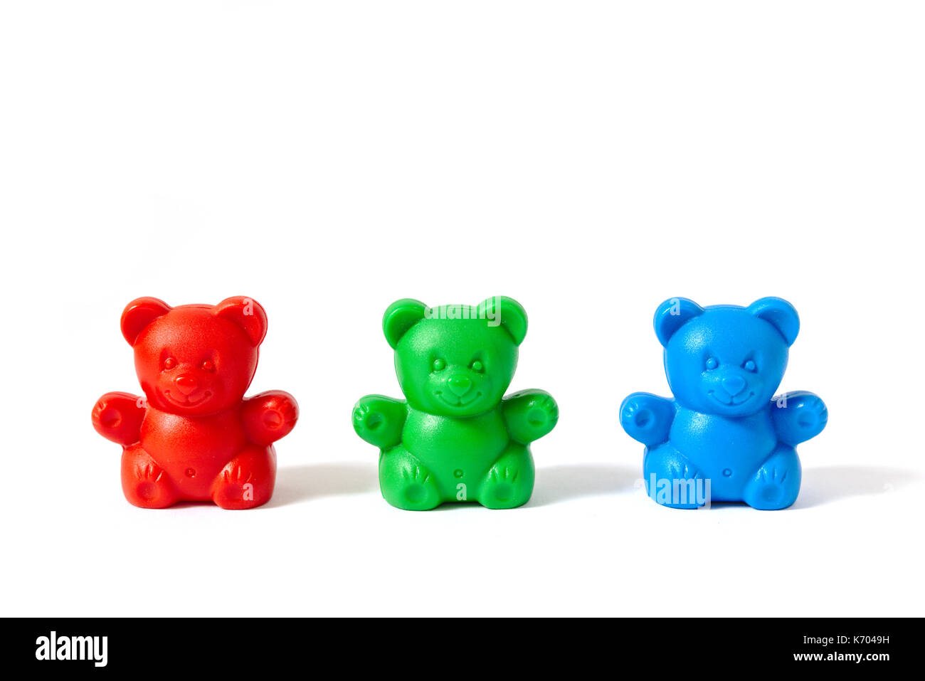 Small red, green and blue plastic toy bears isolated on white background Stock Photo