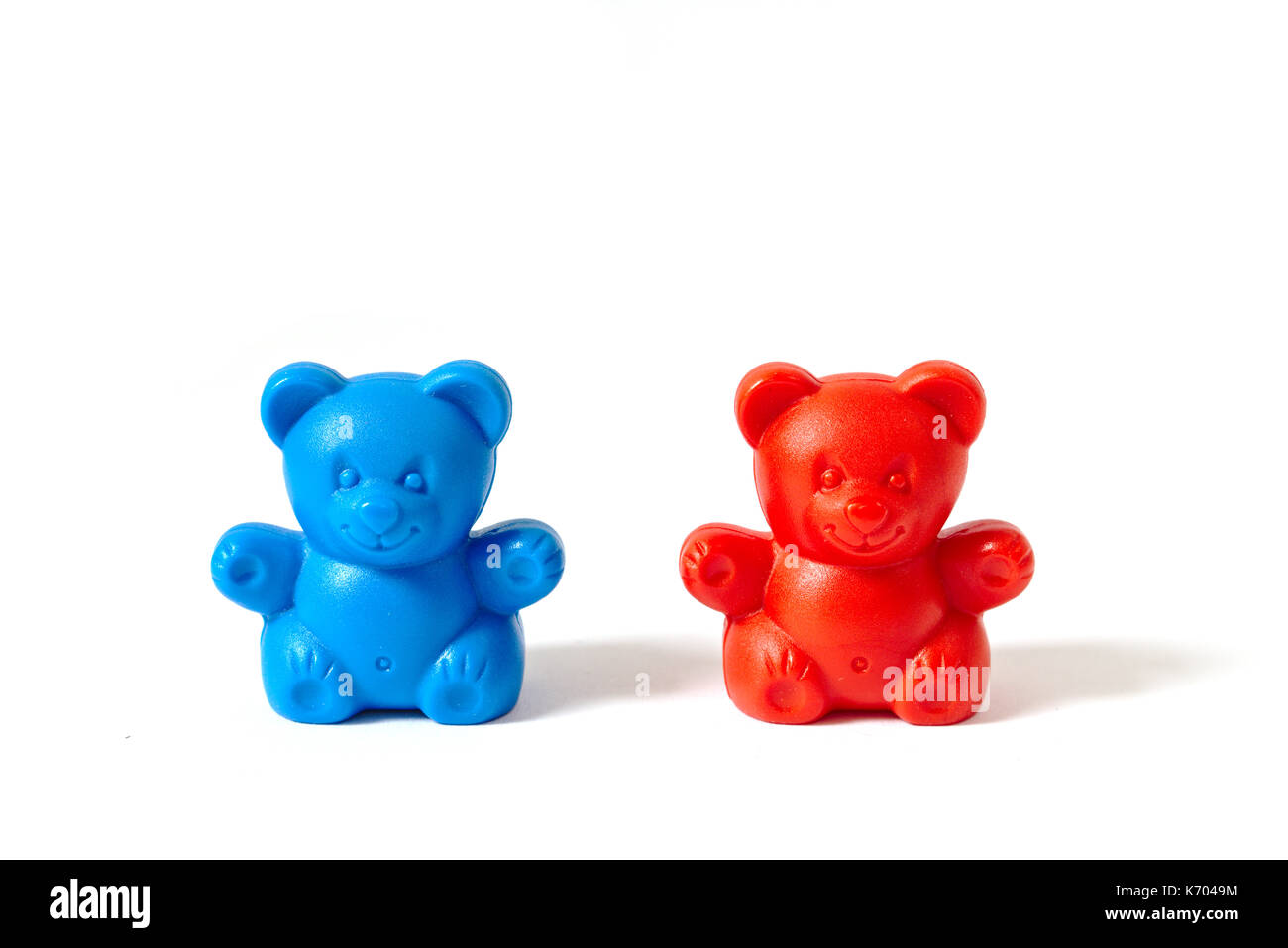 Small red and blue plastic toy bears isolated on white background Stock Photo
