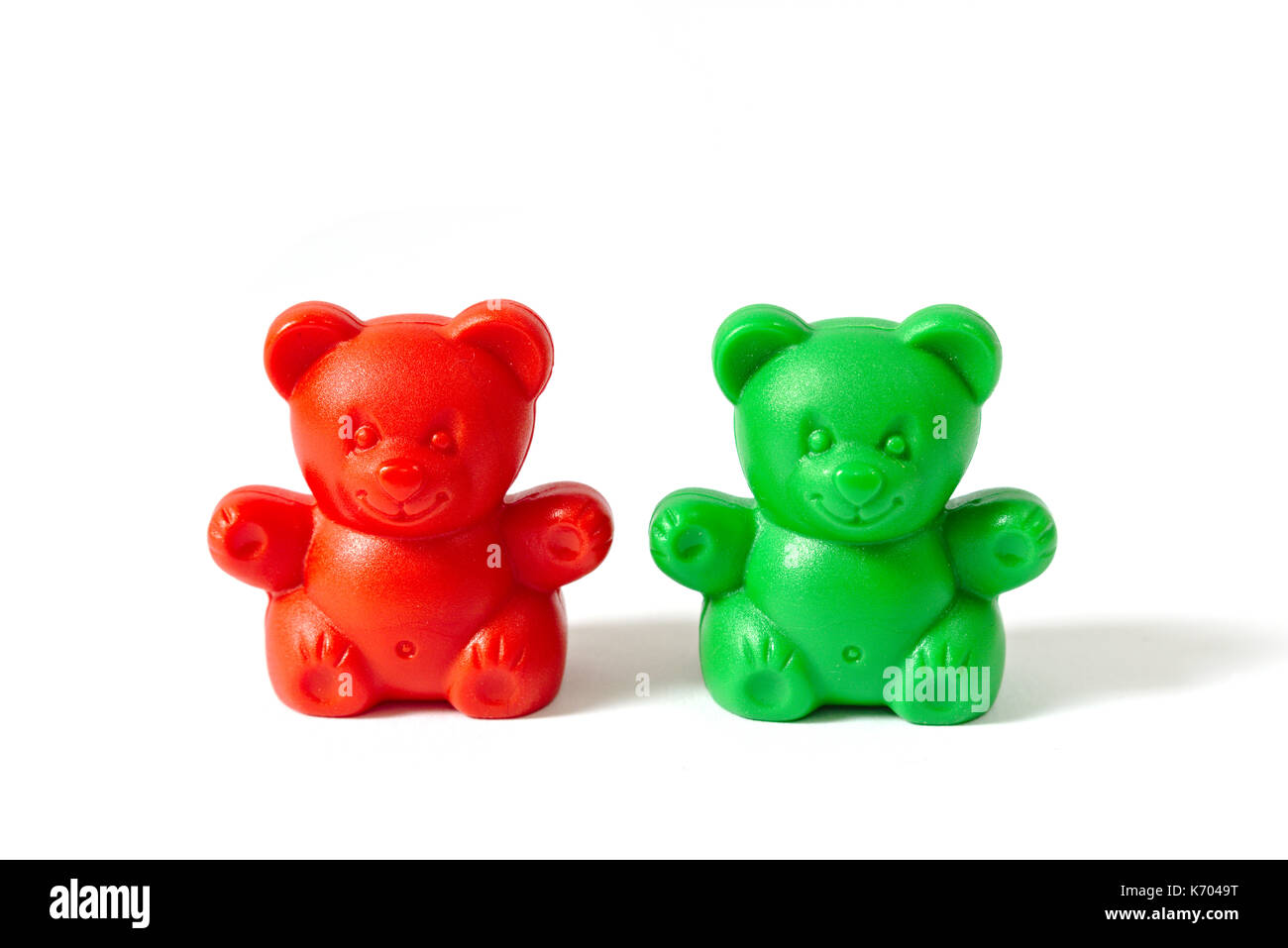 Small red and green plastic toy bears isolated on white background Stock Photo