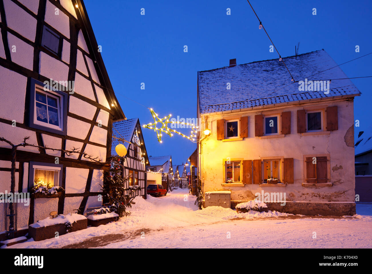 An alley with half-timbered houses and christmas lights at night during snowfall in Lachen, Neustadt an der Weinstrasse, Germany. Stock Photo