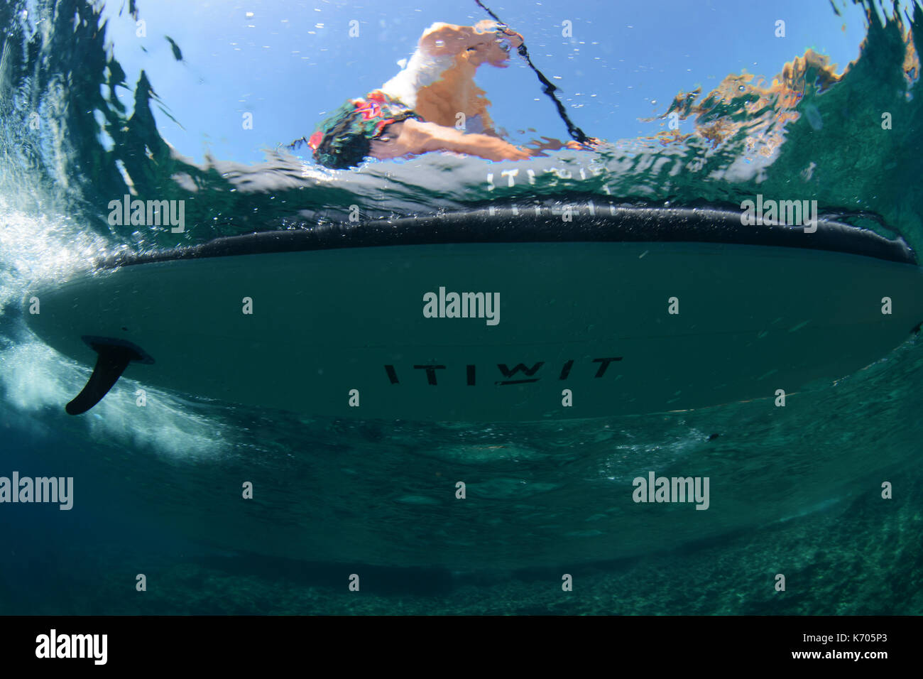 Women Paddleboarder underwater on a wave in the Mediterranean Sea Stock Photo