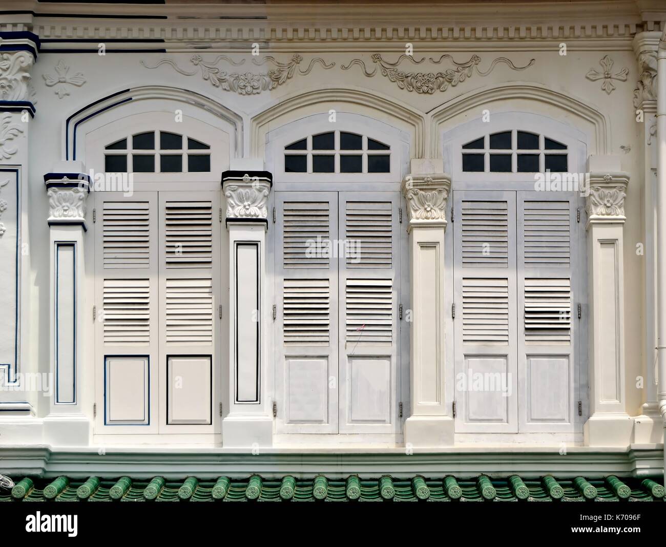 Traditional shop house exterior with white wooden louvered shutters and