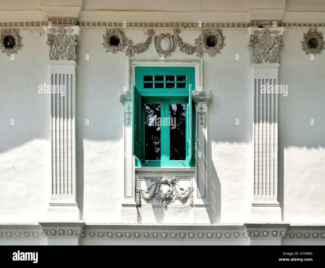 Traditional shop house exterior with white facade, window green wooden louvered shutters and ornate carvings in Singapore's historic Everton Park Stock Photo