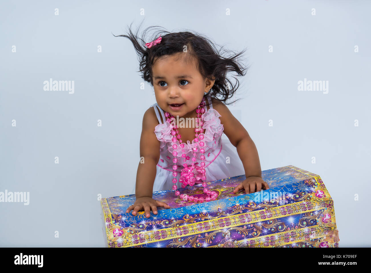 Cute toddler girl dress up in beads with her treasure chest Stock Photo