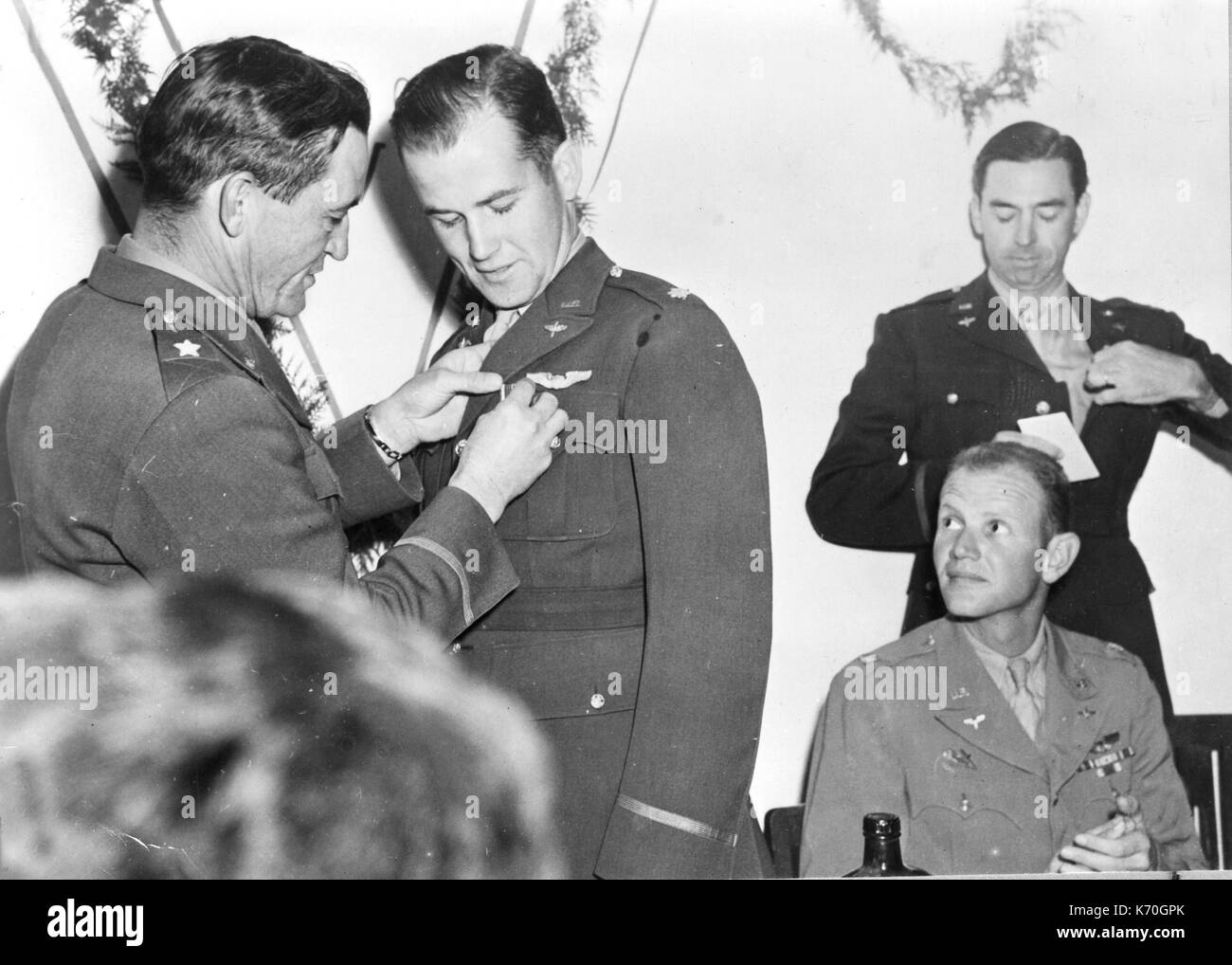 Brig. Gen. Claire Chennault (left) commander of the US Air Task Force, decorates Major Edward F. Rector with the Distinguished Flying Cross. Other officers decorated by Chennault were Major David Hill (seated) and Col. Robert L. Scott (standing). 1943. Stock Photo