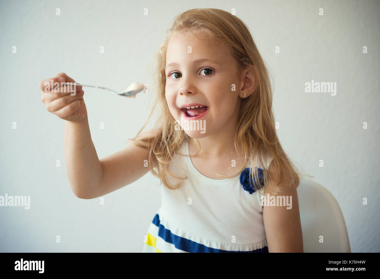 Adorable little child girl eating fruit yogurt at home Stock Photo Alamy