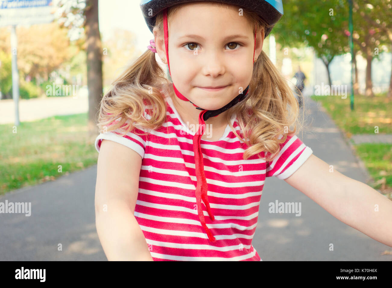 Pretty little child girl ride and having fun with bicycle in summer ...