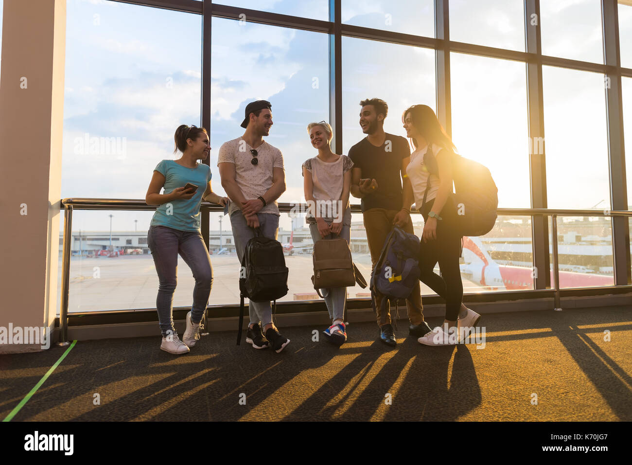 Young People Group In Airport Lounge Near Windows Waiting Departure ...