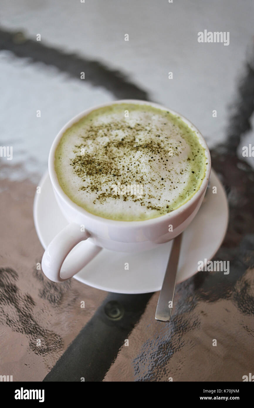 Hot green teas in white mug on food table in the restaurant cafe. Stock Photo