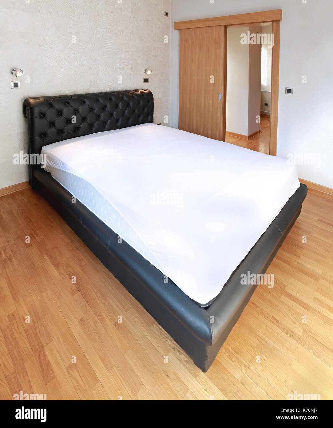 Empty Bed With White Sheet Inside Modern Bedroom Stock Photo