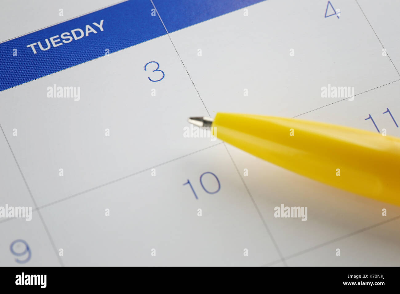 yellow pen points to the number 3 on calendar background in concept of ...