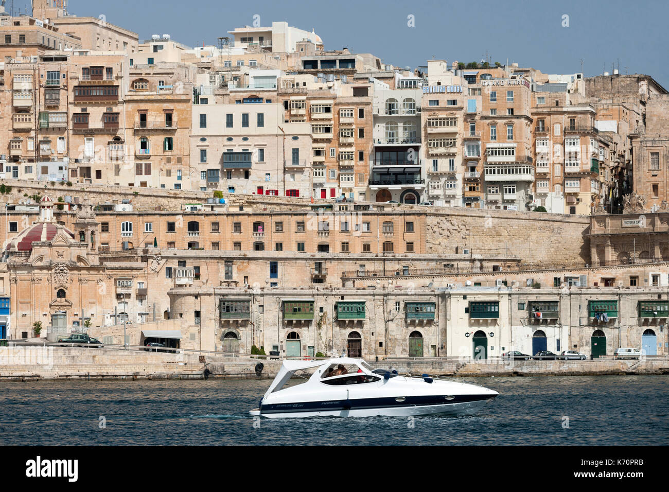 Boat seen against part of the old town of Valletta, the capital of Malta. Stock Photo