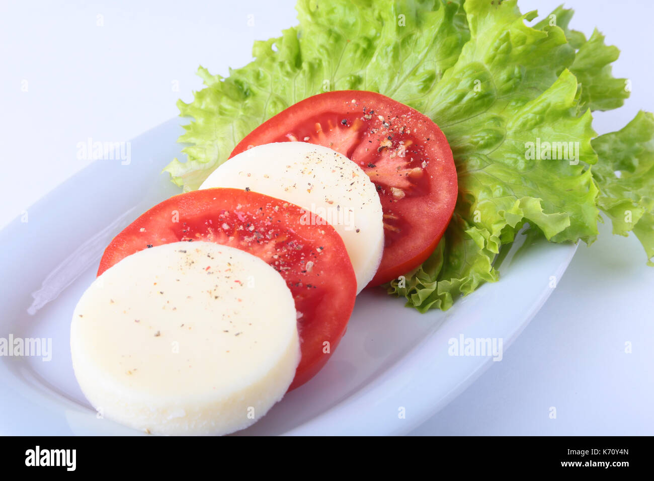 Portion of Mozzarella with Tomatoes, lettuce leaf and Balsamic dressing