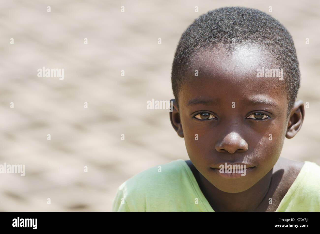 African black boy working outdoors - Child Labour - with blurred background Stock Photo