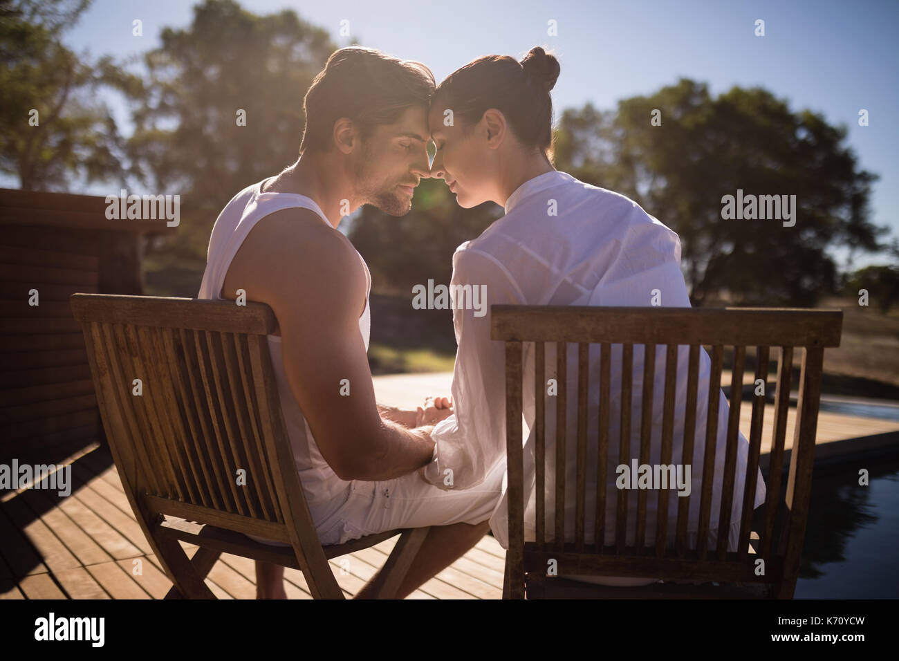 Romantic couple sitting together on chair at safari vacation Stock