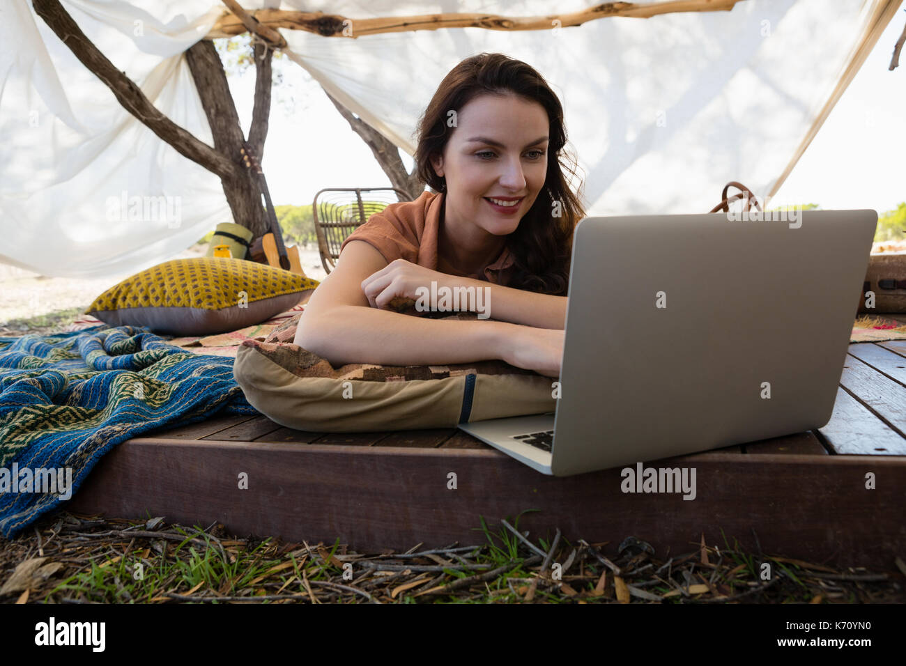 Young woman using laptop while relaxing in tent Stock Photo