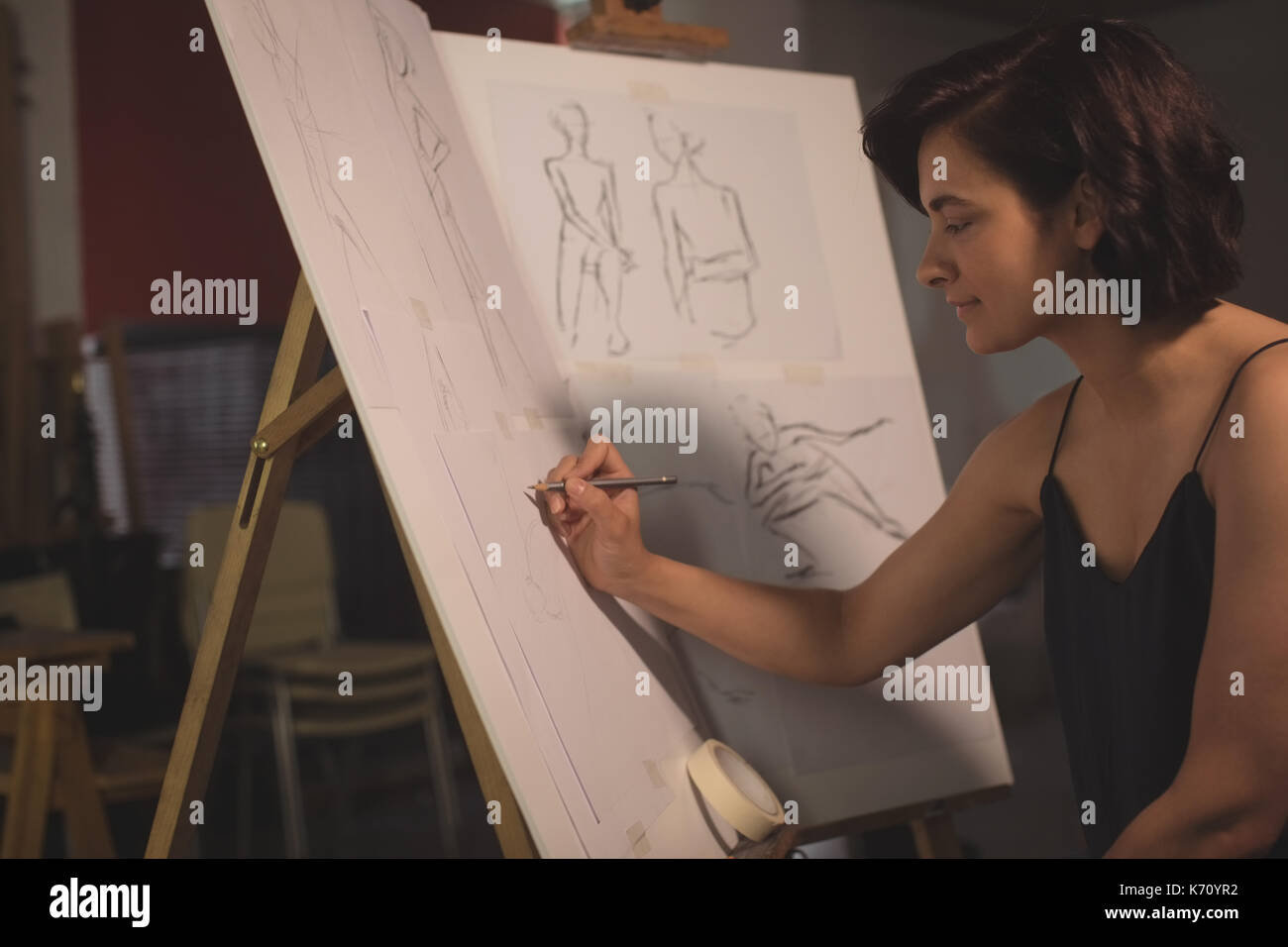 Female artist drawing a sketch on canvas in art studio Stock Photo