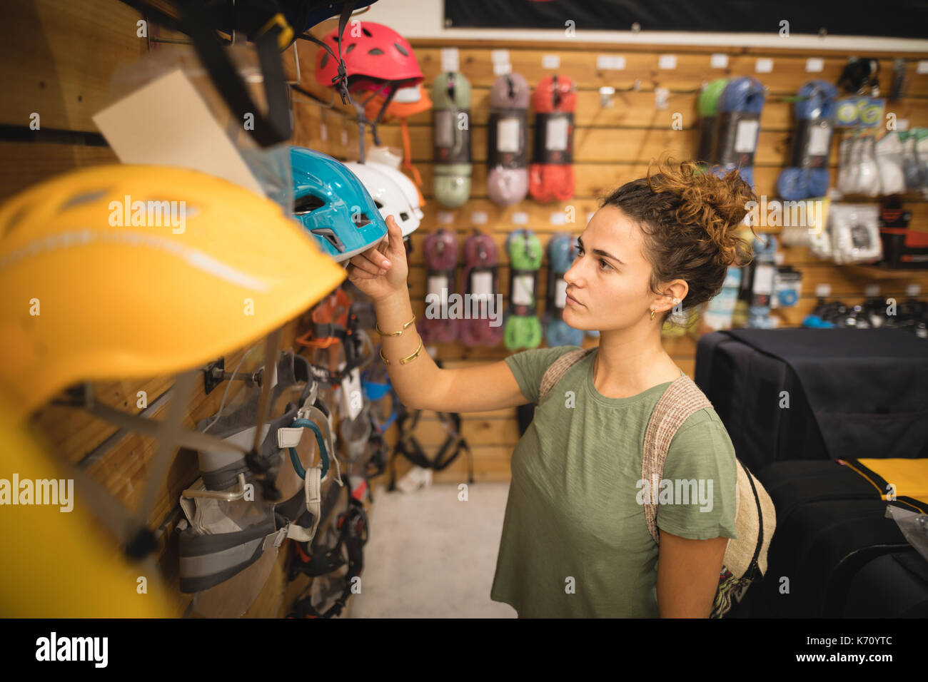 Young woman looking sports helmet in store Stock Photo