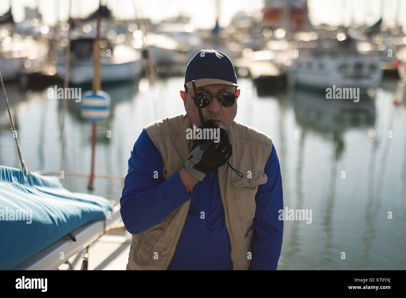 Yachtsman using walkie talkie on pier Stock Photo