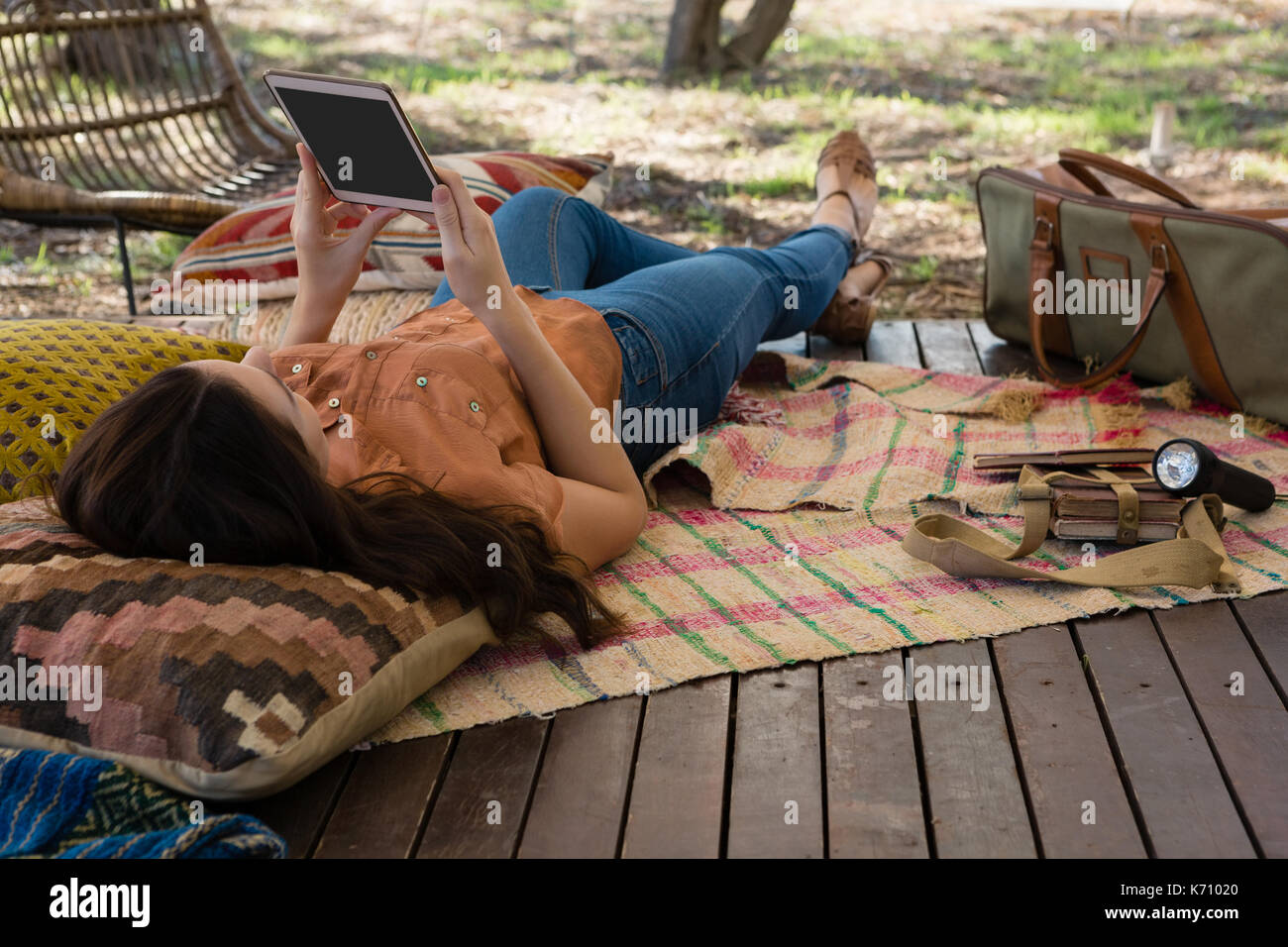 Woman using digital tablet while lying down in tent Stock Photo