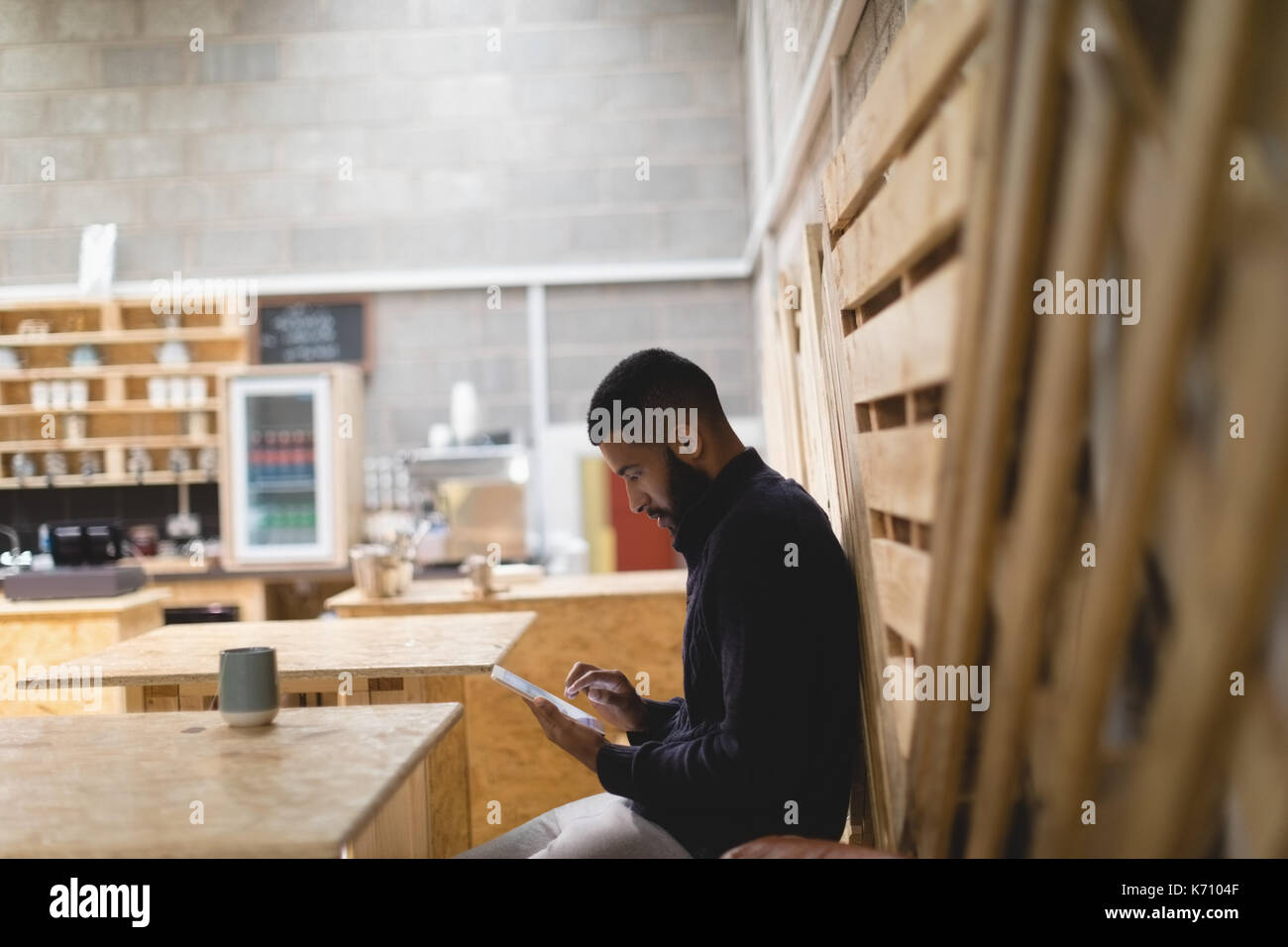 Side view of young man using digital tablet while sitting in cafe Stock Photo