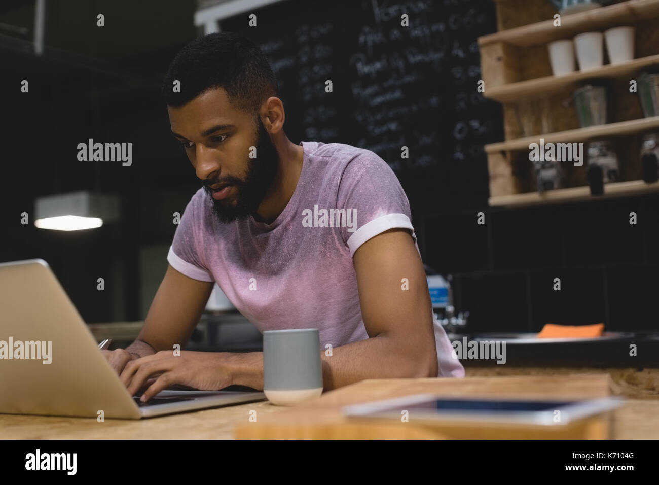 Young man using laptop computer while sitting at table in cafe Stock Photo