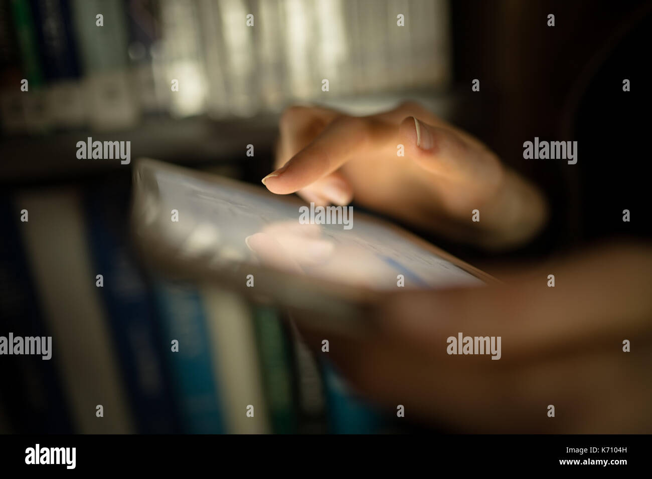 Close-up of woman using digital tablet in library room Stock Photo