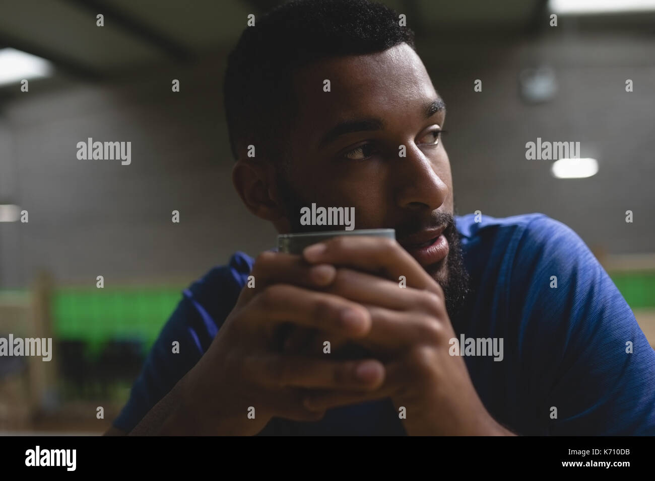 Close up of thoughtful young man looking away while having coffee in cafe Stock Photo