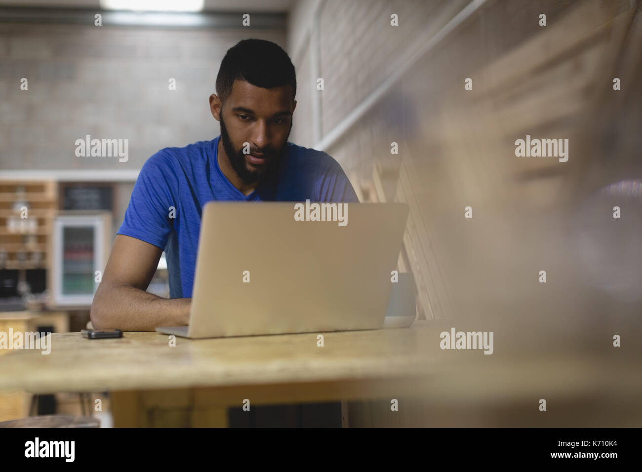 Young man using laptop while sitting in coffee shop Stock Photo